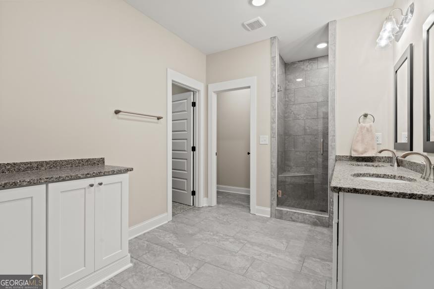 340 Happy Hollow Road Roopville, GA 30170 - Photo 9 of 22 a bathroom with a granite countertop sink a mirror and a shower