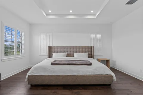 a bedroom with a large bed and wooden floor