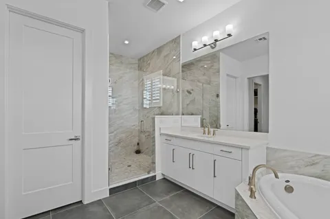 a spacious bathroom with a granite countertop sink mirror and shower