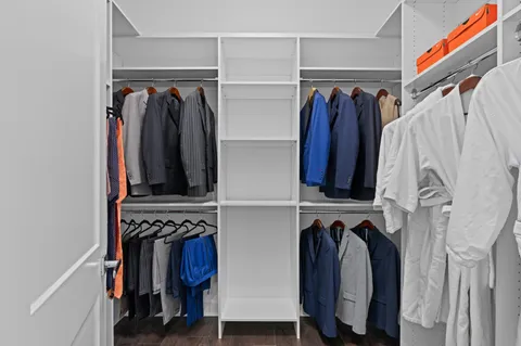 a view of walk in closet with clothes and shoes