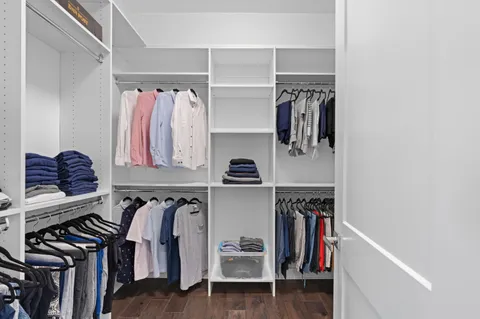 a view of walk in closet with clothes and shoes