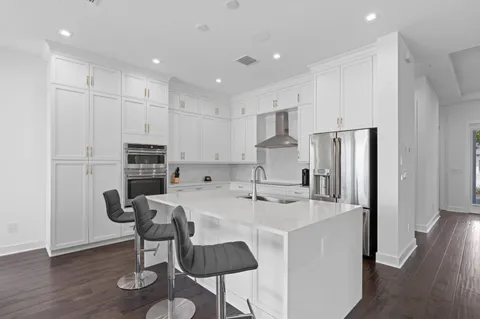 a kitchen with kitchen island a appliances dining table and chairs