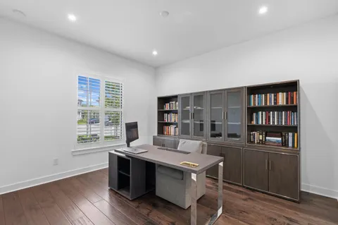 a view of a workspace with furniture and a bookshelf