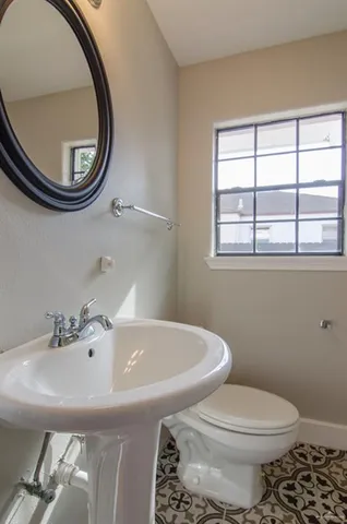 a bathroom with a sink a toilet and a mirror