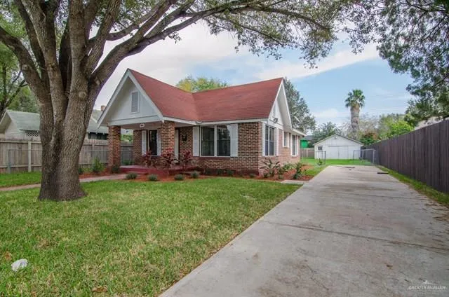 a view of a house with a yard and tree s