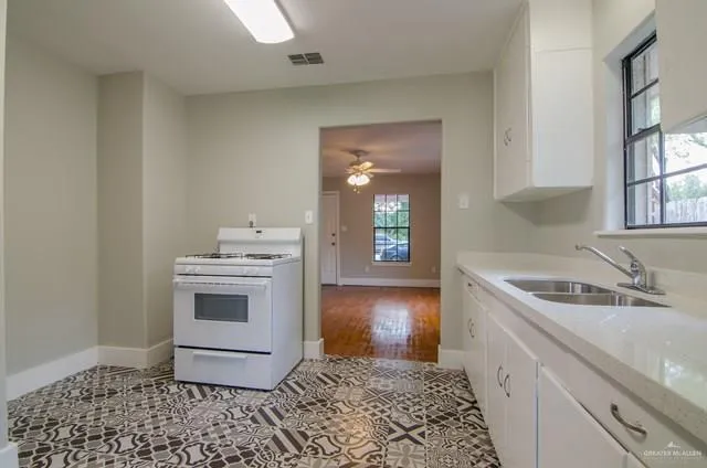 a kitchen with a sink stove and cabinets