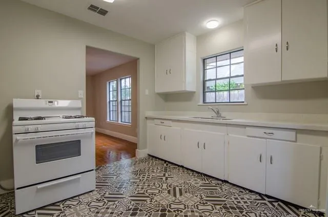 a kitchen with granite countertop white cabinets and white appliances