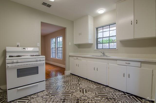 1112 North 16th Street McAllen, TX 78501 - Photo 9 of 21 a kitchen with granite countertop white cabinets and white appliances
