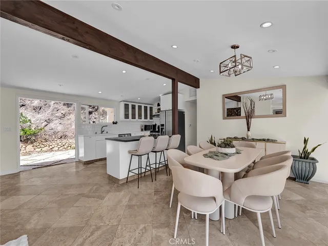 a dining room with furniture a window and a flat screen tv
