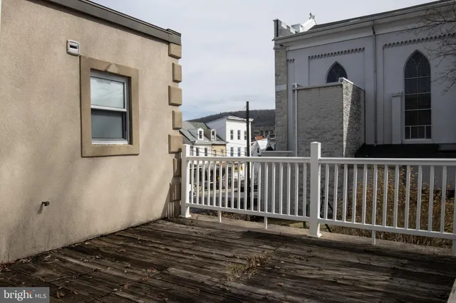 a view of a house with a small yard and wooden floor and fence