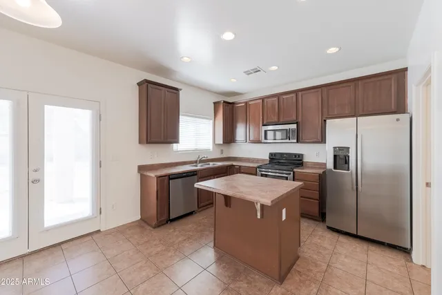 a view of an empty room with a chandelier fan