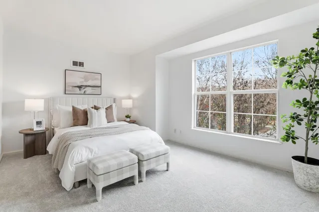 a spacious bedroom with a bed and a large window