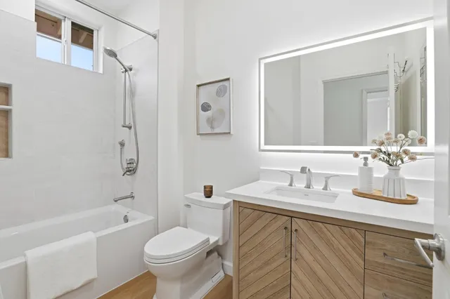 a bathroom with a granite countertop toilet sink and a bathtub