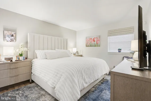 a bedroom with a large bed and a flat screen tv