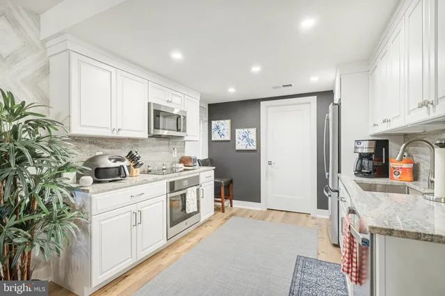 a kitchen with stainless steel appliances granite countertop a stove a sink and a refrigerator