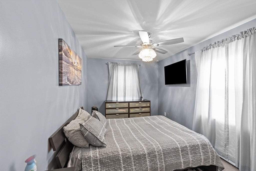 10 Silver Shell Beach Drive Fairhaven, MA 02719 - Photo 27 of 41 a bedroom with a bed and a chandelier