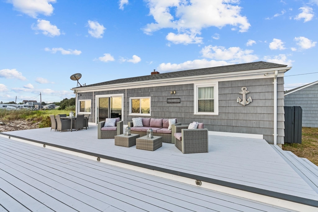 10 Silver Shell Beach Drive Fairhaven, MA 02719 - Photo 3 of 41 a view of a patio with dining table and chairs with wooden floor