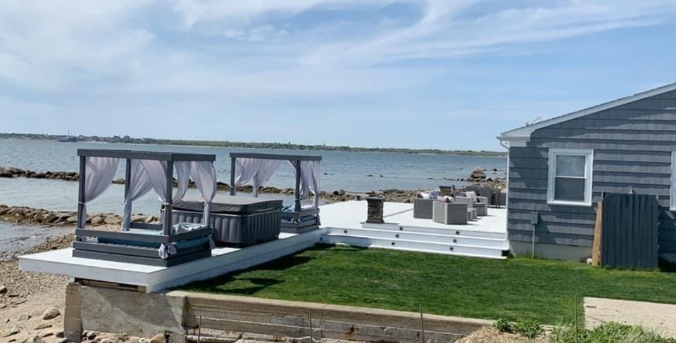 10 Silver Shell Beach Drive Fairhaven, MA 02719 - Photo 34 of 41 a view of a deck with couches chairs and floor to ceiling window