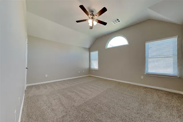 an empty room with window and chandelier fan