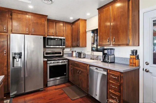 a kitchen with stainless steel appliances granite countertop a refrigerator stove and sink