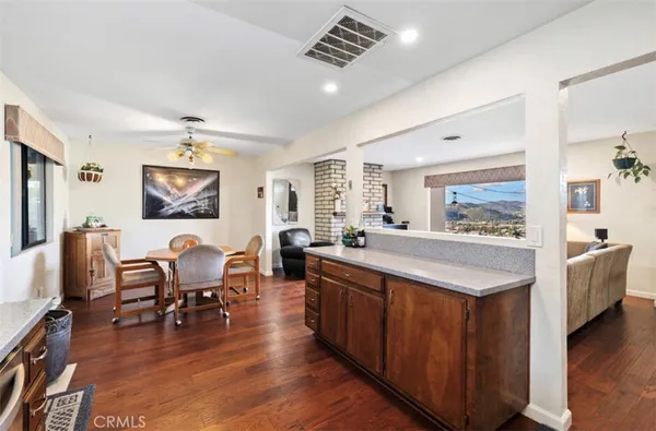 a large living room with stainless steel appliances granite countertop furniture wooden floor and a window