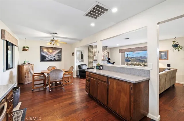 a large living room with stainless steel appliances granite countertop furniture wooden floor and a window