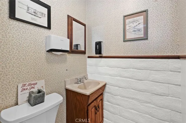 a bathroom with a toilet a sink and mirror