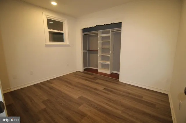 a view of empty room with wooden floor and windows