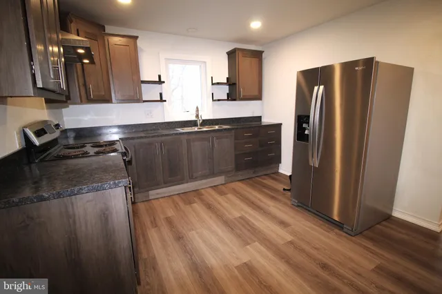 a kitchen with stainless steel appliances granite countertop a refrigerator and a sink