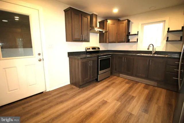 a kitchen with stainless steel appliances granite countertop a sink stove and cabinets