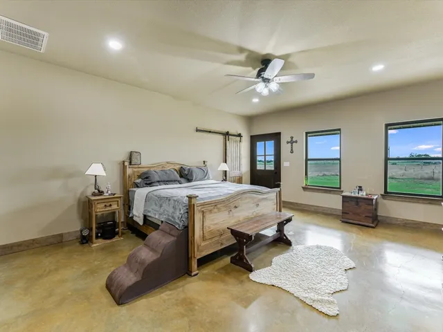 a spacious bedroom with a bed and a flat screen television