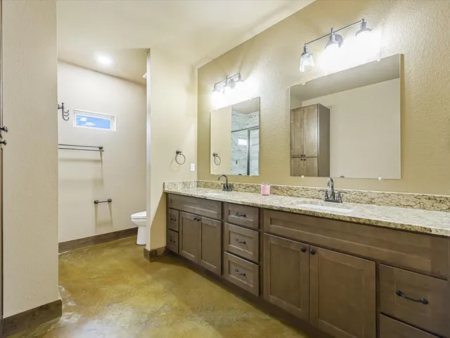 a spacious bathroom with a granite countertop sink mirror and toilet