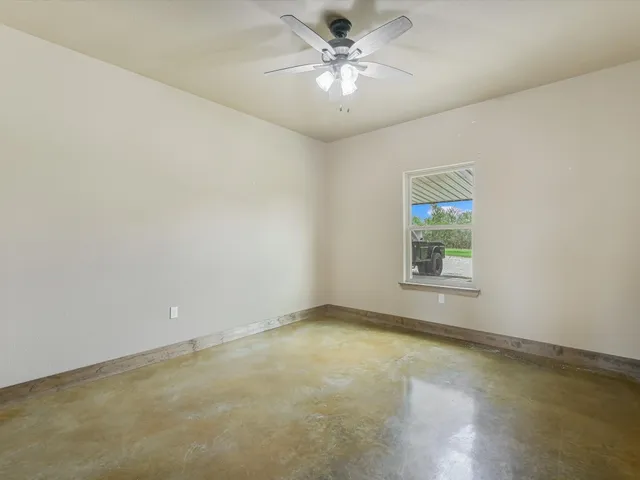 an empty room with a window and a fan