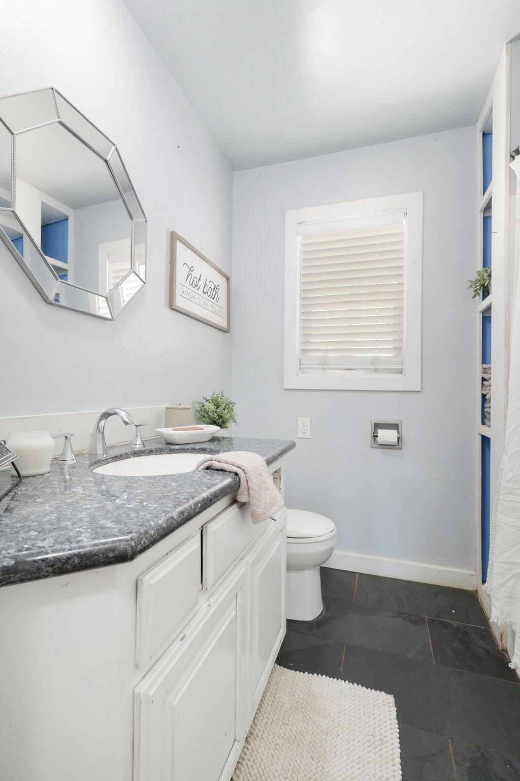 7699 Happy Valley Road Anderson, CA 96007 - Photo 32 of 49 a bathroom with a granite countertop sink toilet and mirror