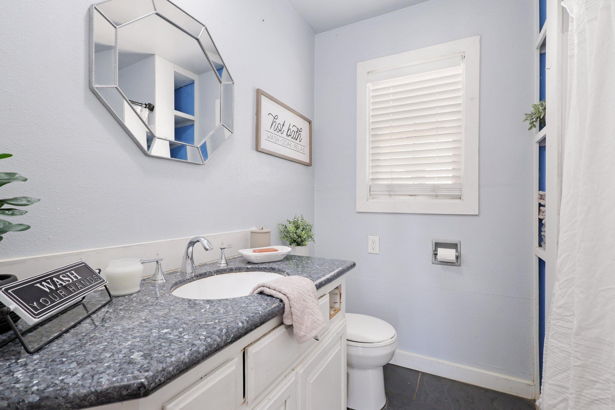 7699 Happy Valley Road Anderson, CA 96007 - Photo 8 of 49 a bathroom with a granite countertop sink and a mirror