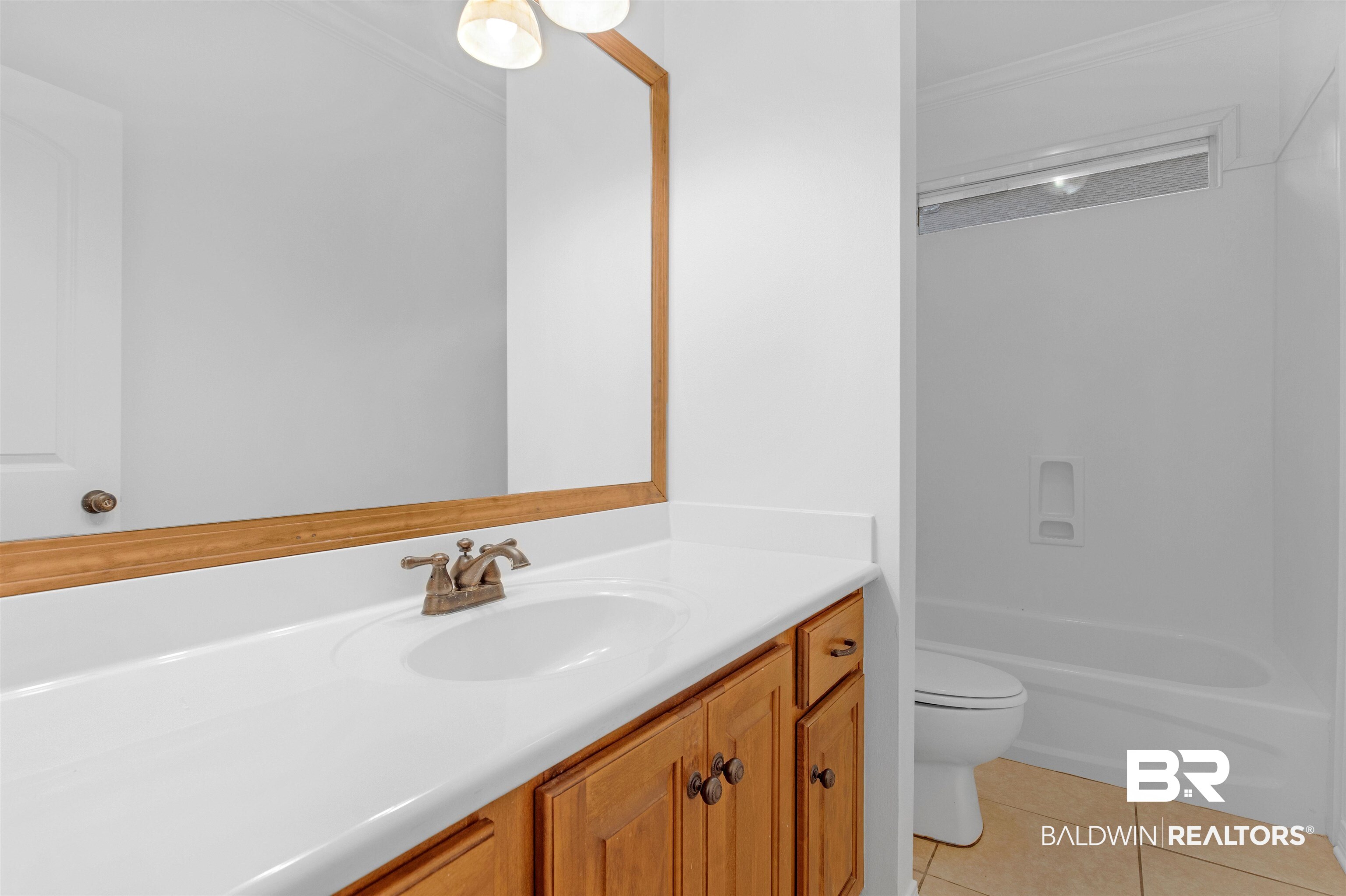 1007 Linlen Avenue Mobile, AL 36609 - Photo 14 of 21 Full bathroom with ornamental molding, vanity, tile patterned floors, toilet, and shower / bathtub combination