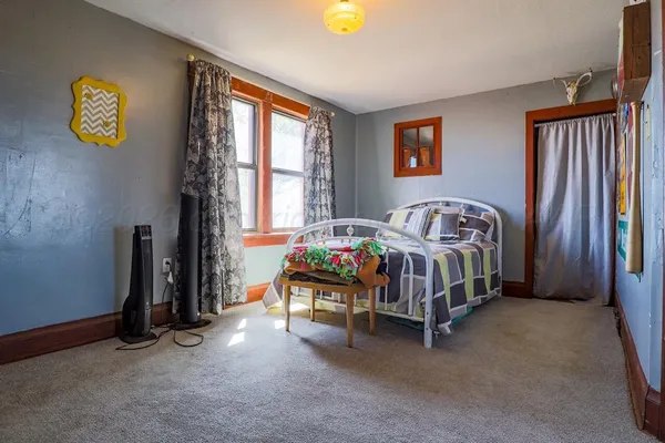 a bedroom with a bed a mirror and a large window