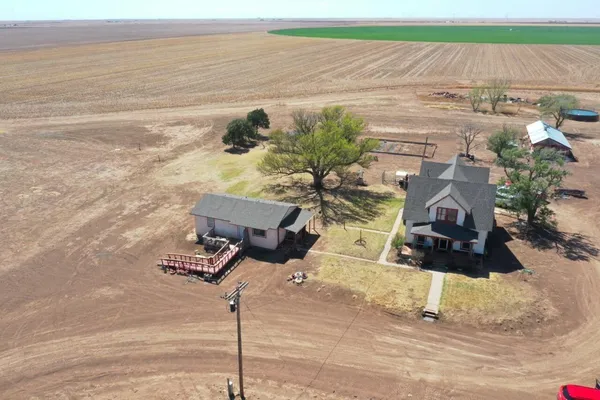 a view of a white house with a yard and sitting area