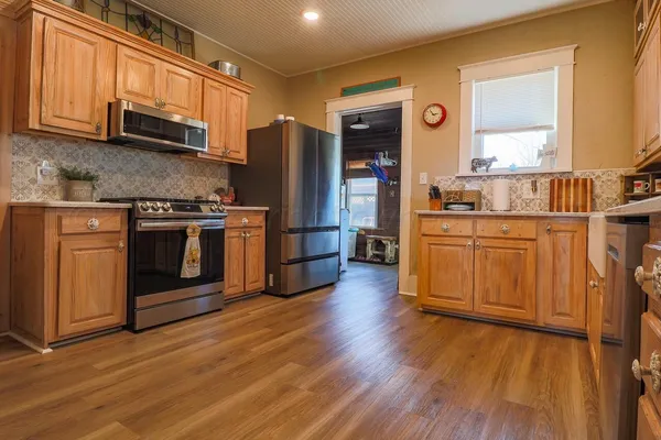 a kitchen with stainless steel appliances granite countertop a sink and cabinets with wooden floor