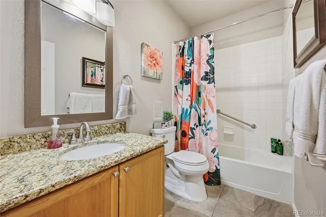 a bathroom with a granite countertop sink a toilet and a bathtub