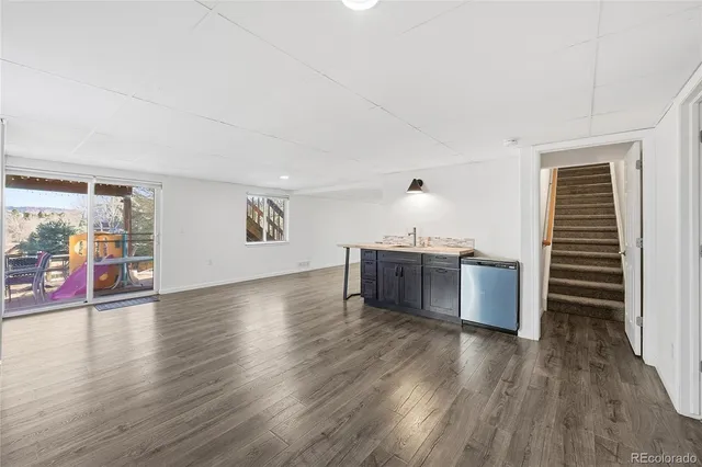 a kitchen with stainless steel appliances wooden floor and a large window