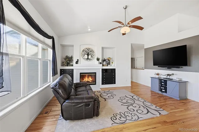 a living room with furniture a flat screen tv and a fireplace