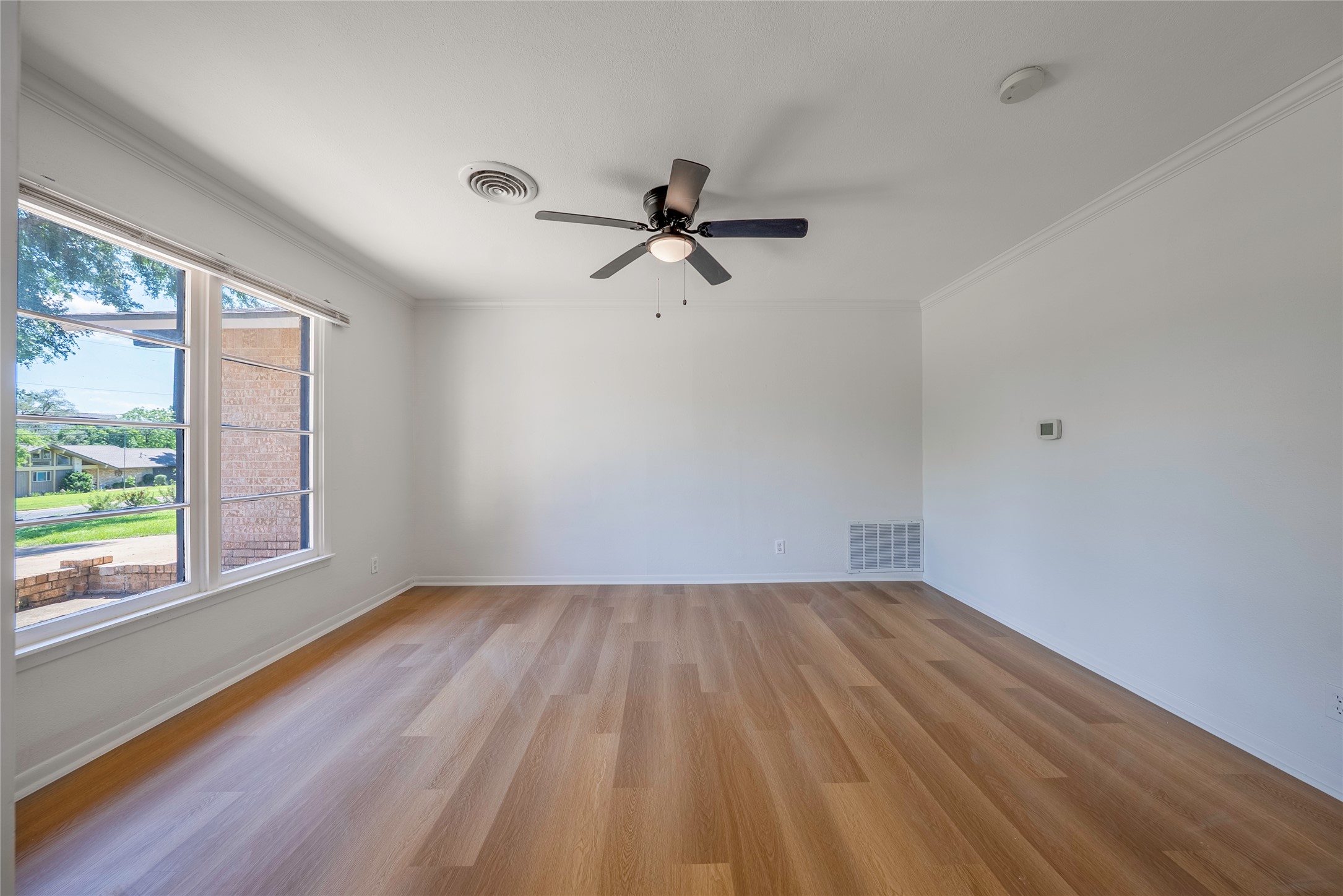 807 Country Club Road Georgetown, TX 78628 - Photo 2 of 28 wooden floor in an empty room with a window