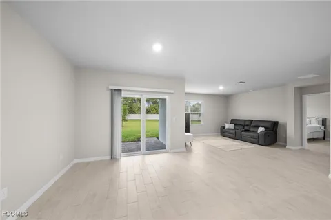 an empty room with floor to ceiling window and carpet