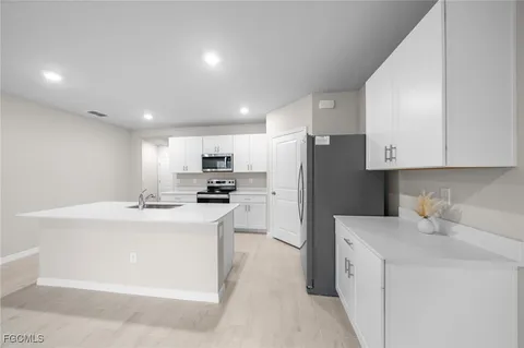 a kitchen with refrigerator and cabinets