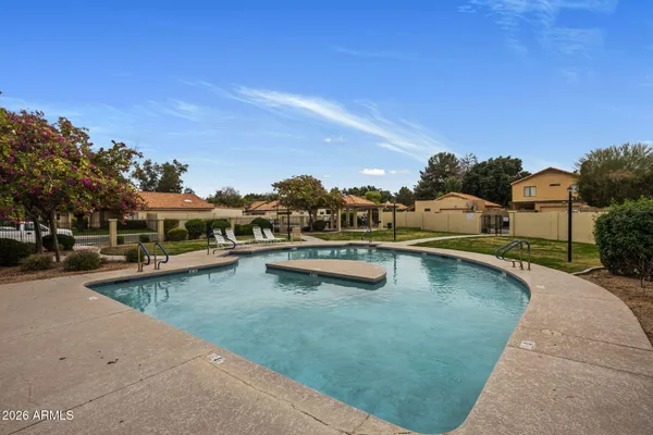 a view of a swimming pool with a patio and a yard