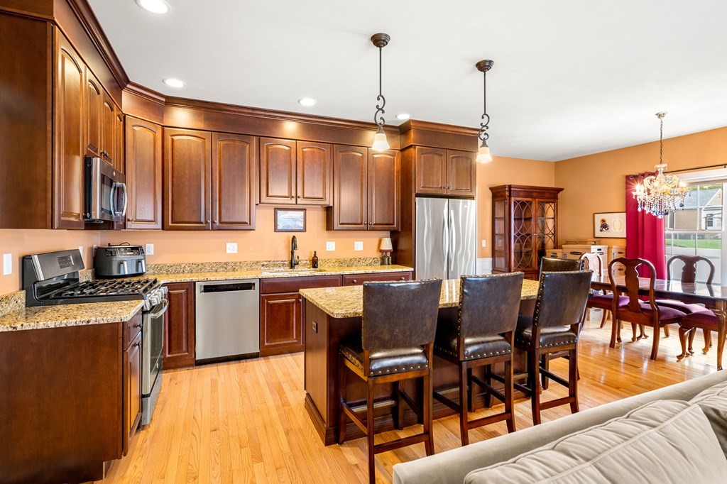 20 Paddock Circle, Unit 20 Salem, NH 03079 - Photo 8 of 29 a kitchen with stainless steel appliances granite countertop a stove top oven a refrigerator a sink and chairs