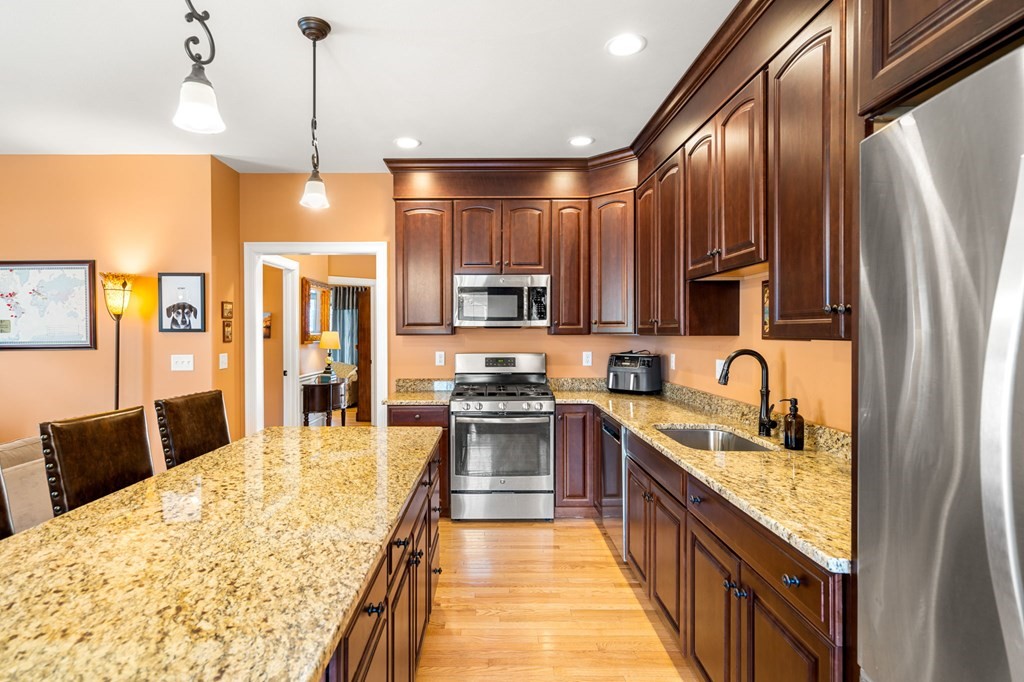 20 Paddock Circle, Unit 20 Salem, NH 03079 - Photo 9 of 29 a large kitchen with stainless steel appliances granite countertop a stove a sink and a refrigerator