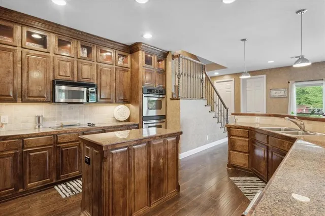 a kitchen with stainless steel appliances granite countertop a sink stove and cabinets