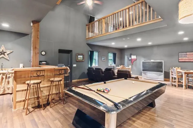 a living room with a table chairs and a dining table with wooden floor
